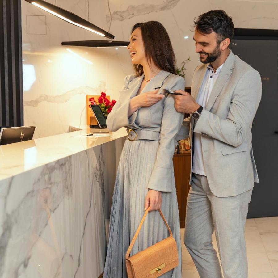 Hotel Pupin Нови Сад Екстериор снимка A man helping a woman with her coat